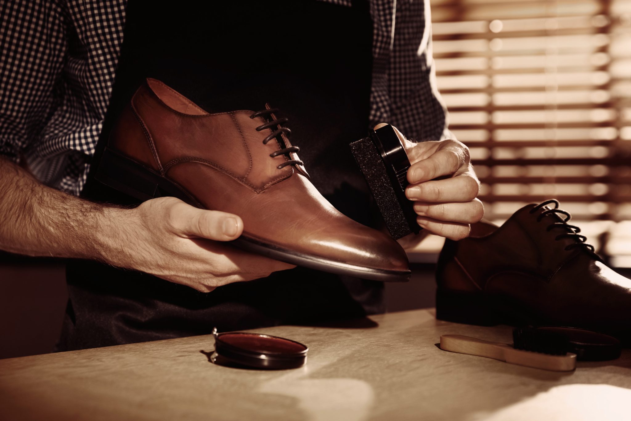 Man taking care of shoes in workshop, closeup