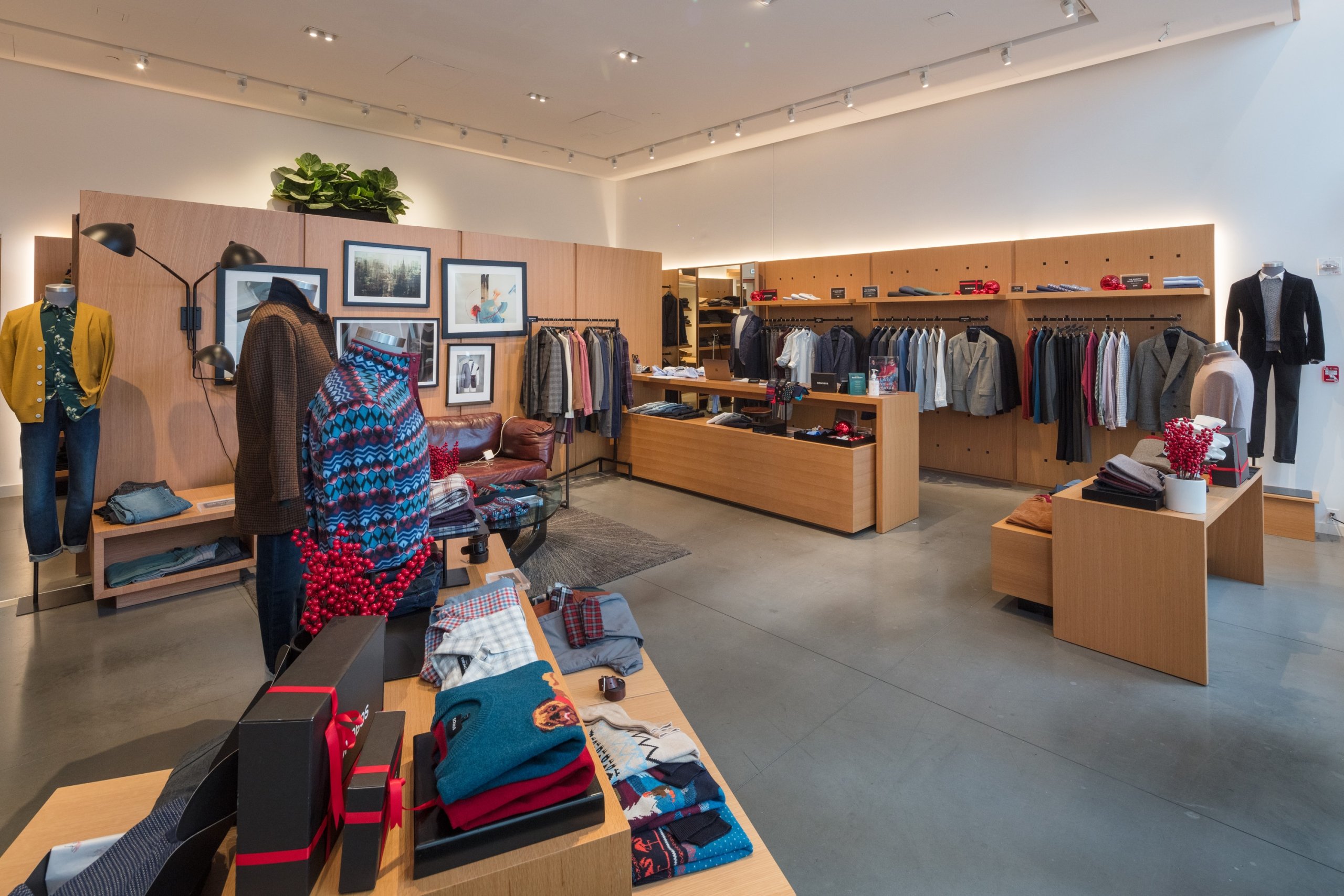 The interior of a bright Bonobos men's apparel store, featuring wood-paneled walls, clothing racks, and display tables with carefully folded merchandise, creating a lounge-like, inviting atmosphere.