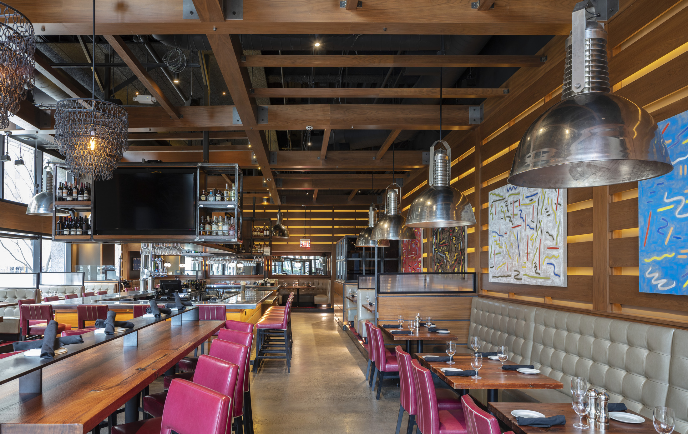 Modern, industrial-style restaurant space with wooden beams, high ceilings, and scattered merchandise.