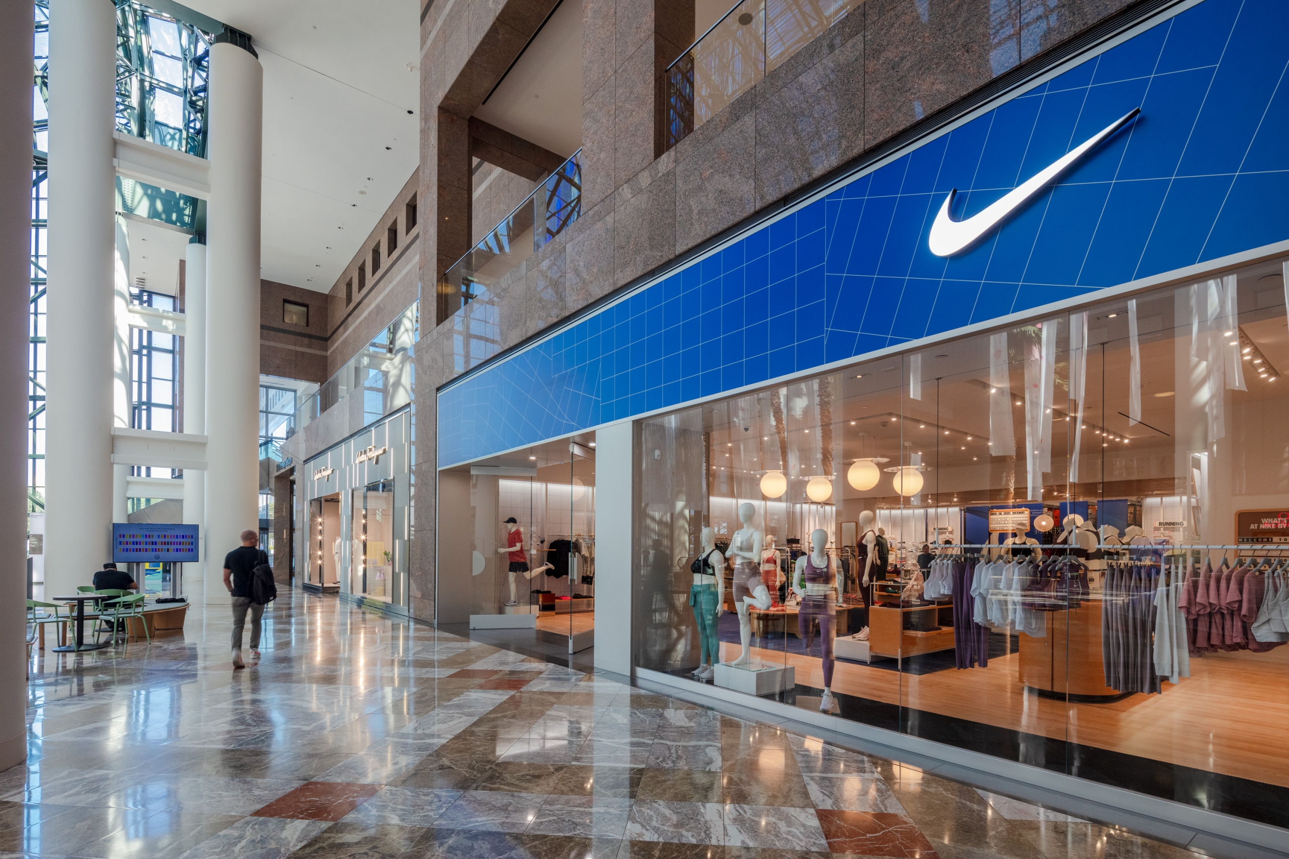 Storefront of a Nike retail location with a large glass window display.