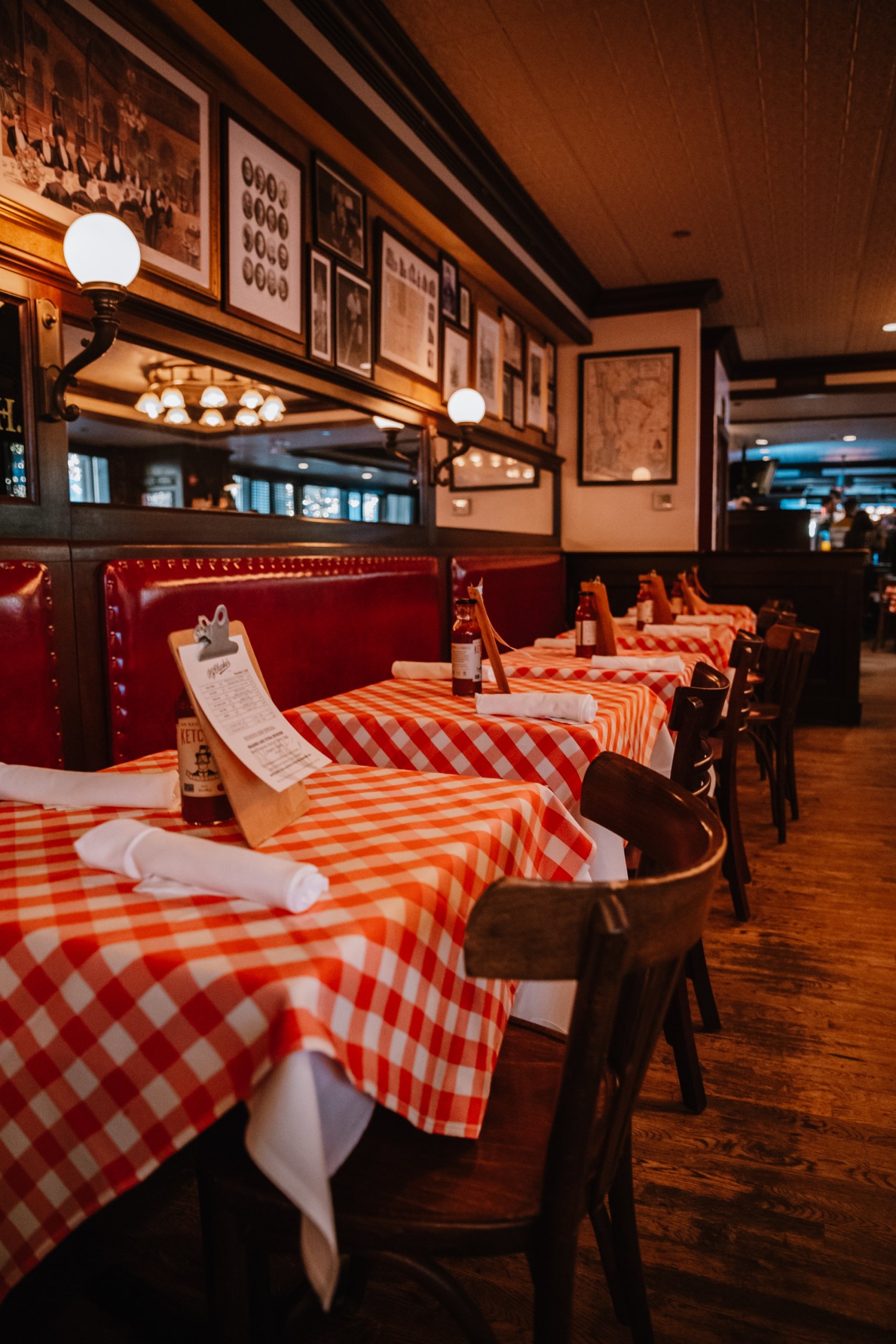 Close-up of a table with a red-and-white checkered tablecloth and a glass of wine or beverage.