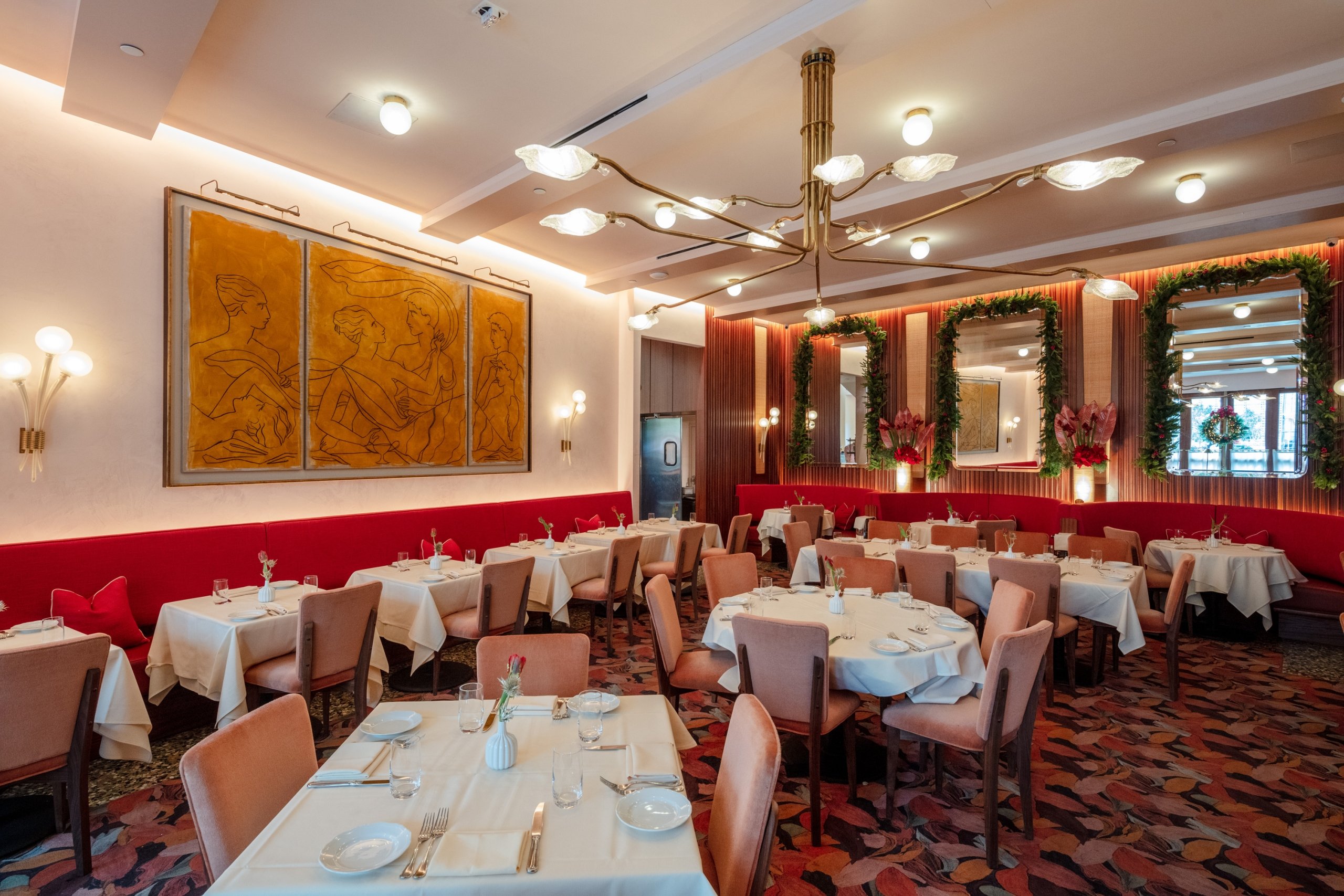 Restaurant interior with red booth seating, wooden tables, and overhead lighting.