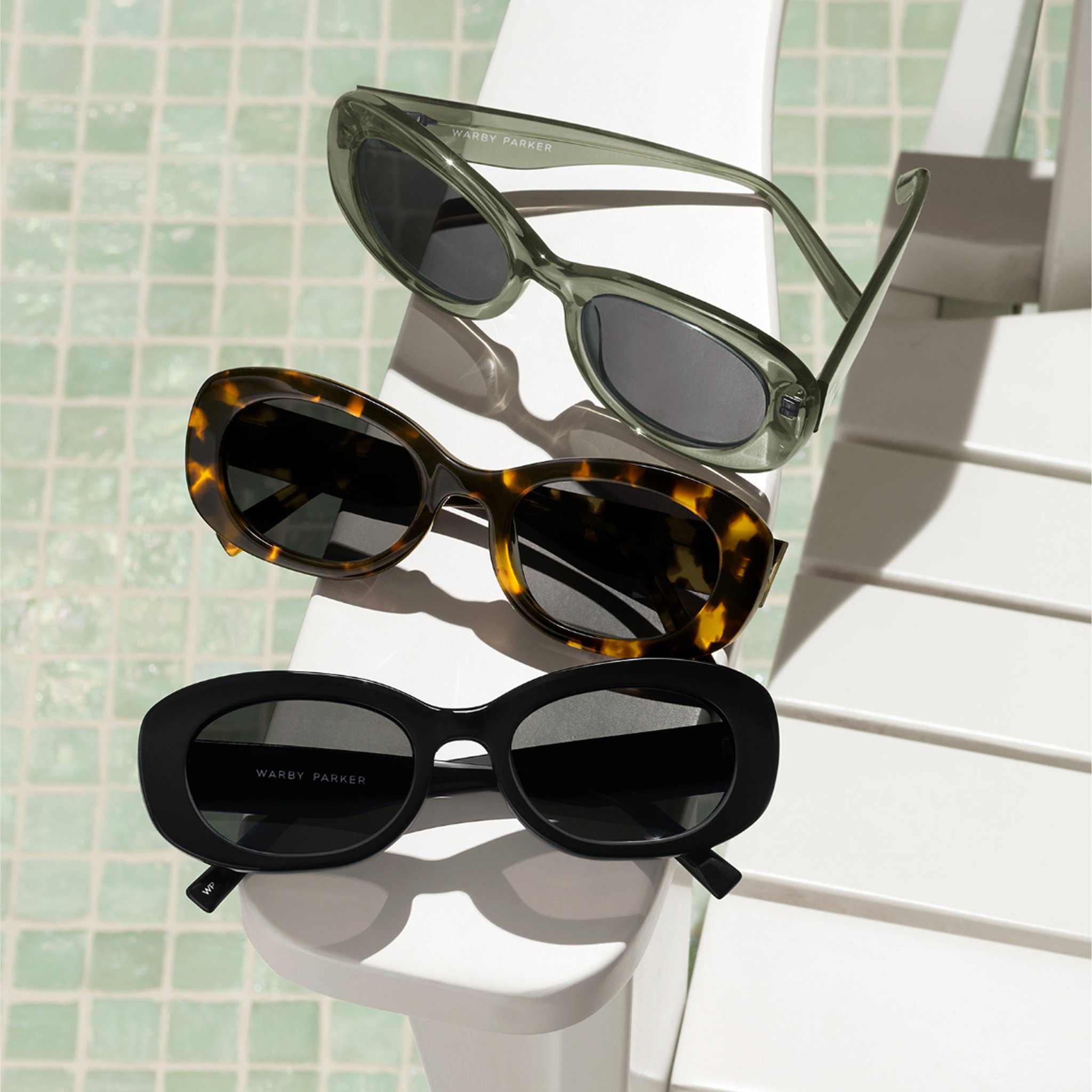 Close-up of a pair of stylish tortoise-shell sunglasses resting on a dark surface.