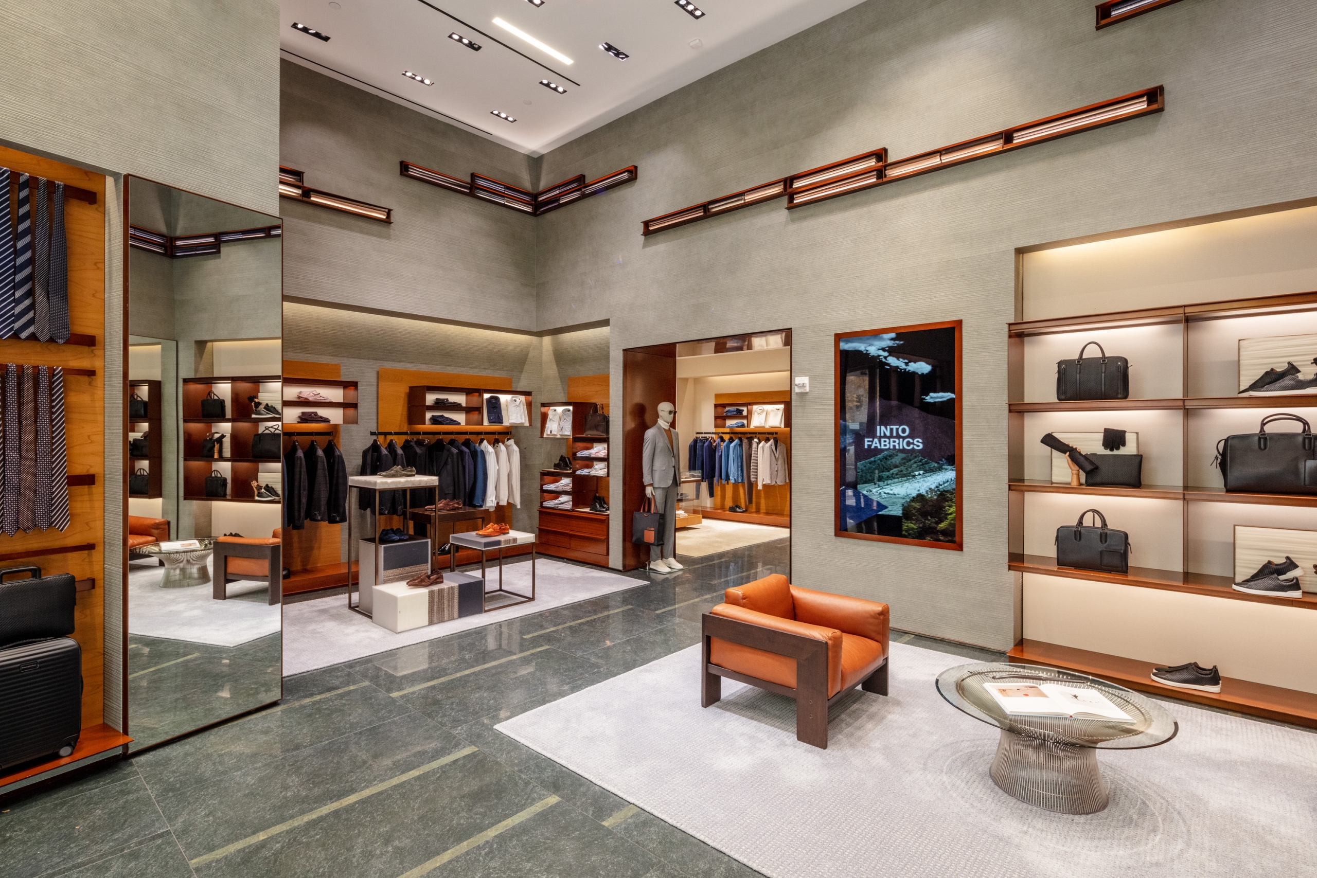Interior of a luxury retail store with comfortable seating, modern furniture, and high-end merchandise displays.